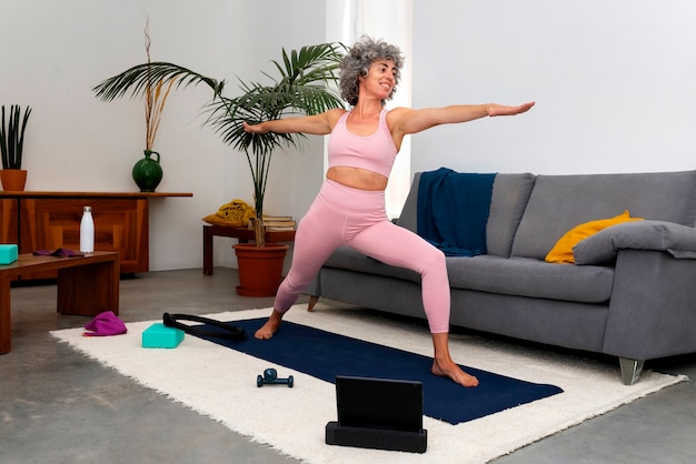 Free photo side view old woman exercising at home