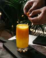 Free photo side view of orange juice on a wooden cutting board