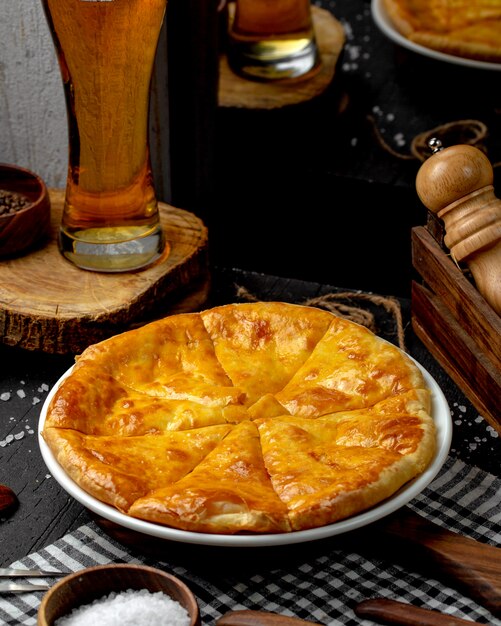 Side view of ossetian pie with cheese on the table