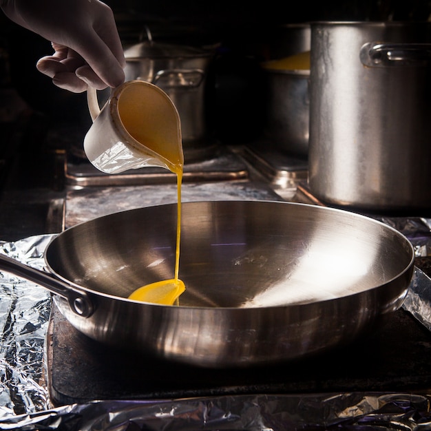 Side view pan with melted butter and human hand in stove