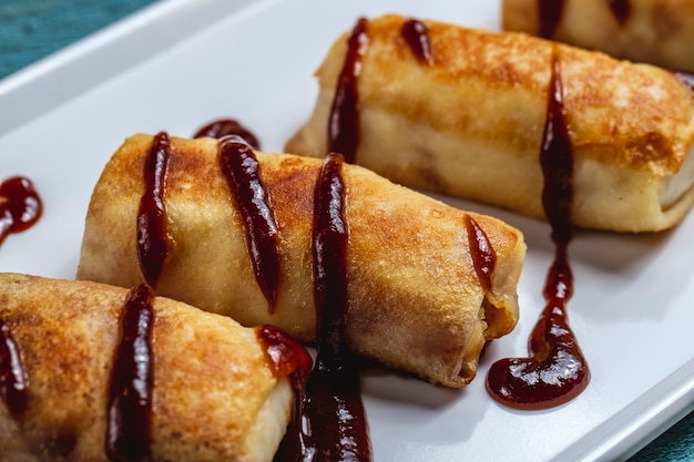 Side view pancakes with sour cream and jam on the table