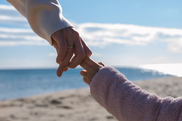 Side view parent and kid holding hands