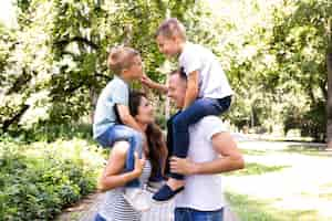 Free photo side view of parents carrying their children