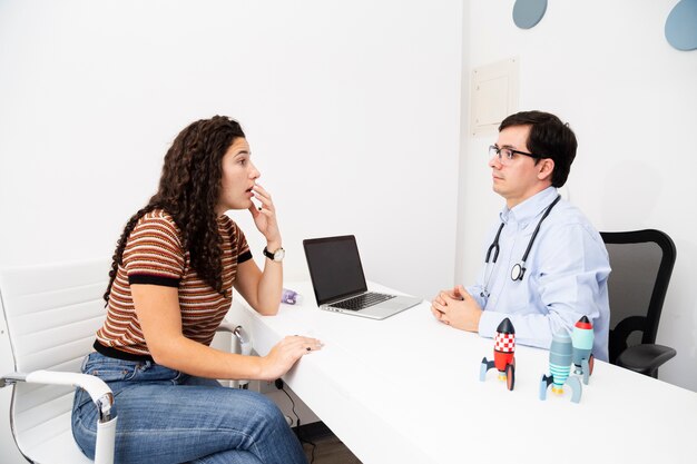 Side view patient speaking to the doctor