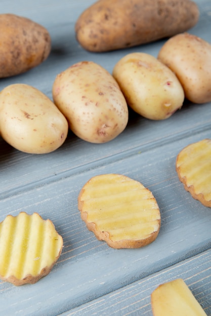 Side view of pattern of potatoes on wooden background