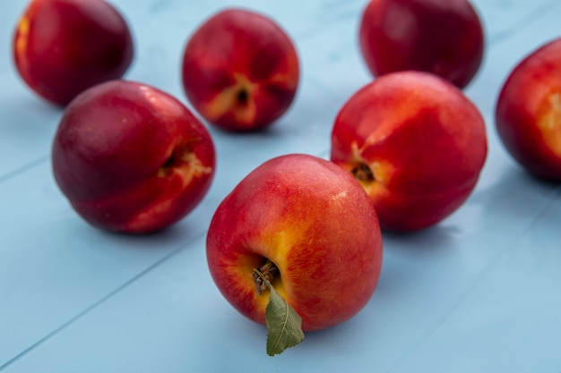 Side view of peaches on a light blue surface