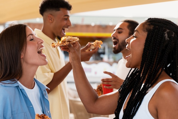 Side view people eating pizza