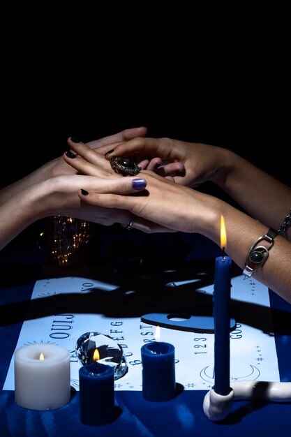 Side view people holding hands with ouija board