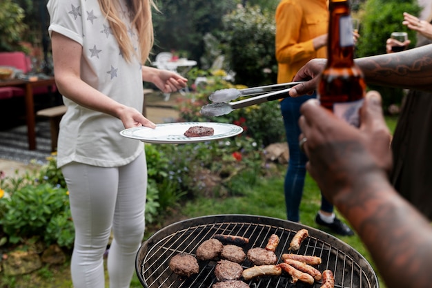 Side view people making barbecue together