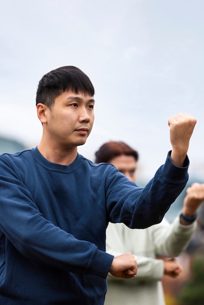 Foto gratuita persone di vista laterale che praticano il tai chi