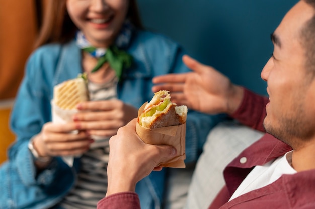 Сбочный вид людей с бумажными сэндвичами