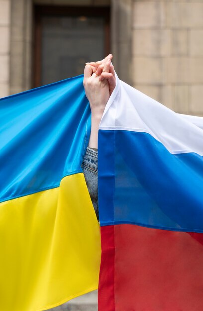 ロシアとウクライナの旗を持つ側面図の人々