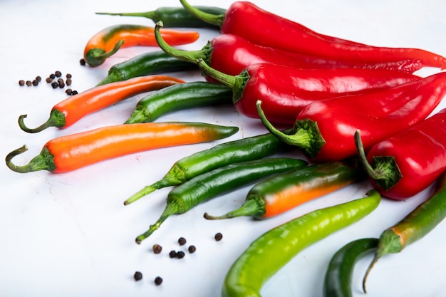 Side view of peppers with pepper spice on white background