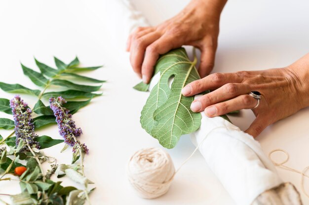 Side view person coloring a cloth with leaves