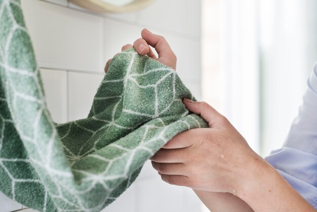 Side view of person drying hands using towel