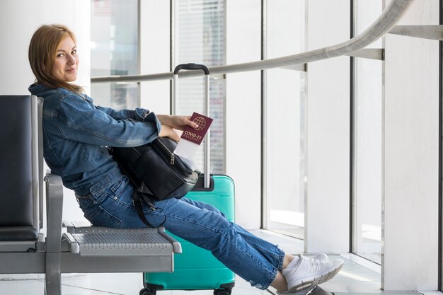 Side view of person holding health passport at the airport