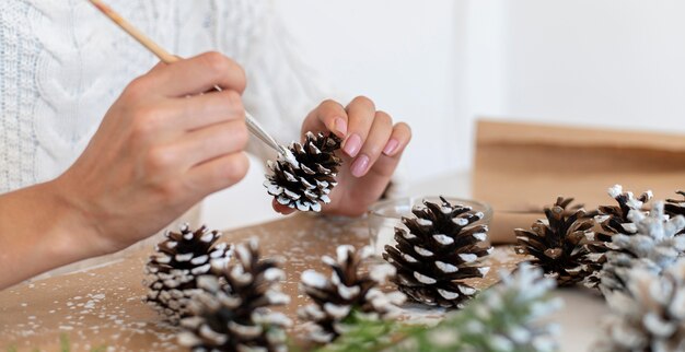 Side view of person paining pine cones for christmas