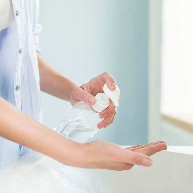 Side view of person using liquid soap at the bathroom sink