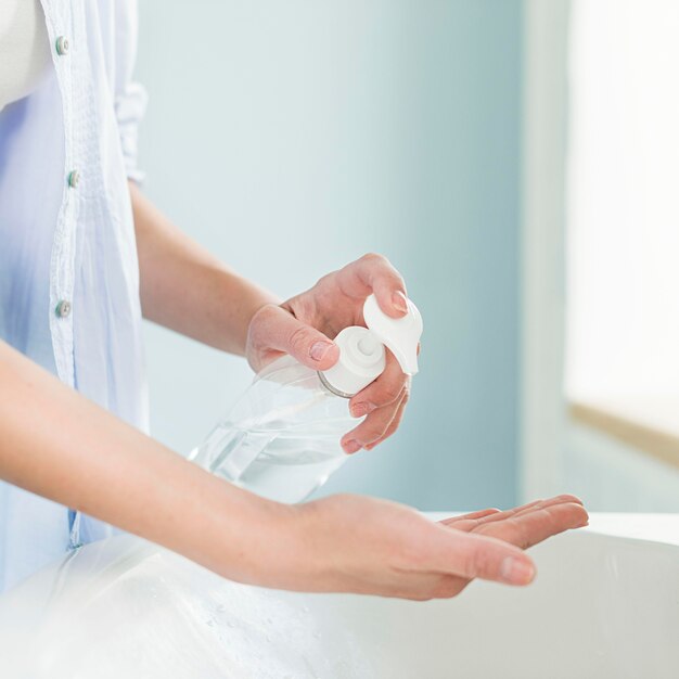 Side view of person using liquid soap at the bathroom sink