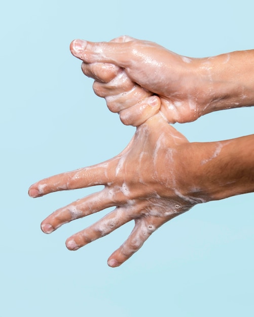 Side view person washing hands isolated on blue