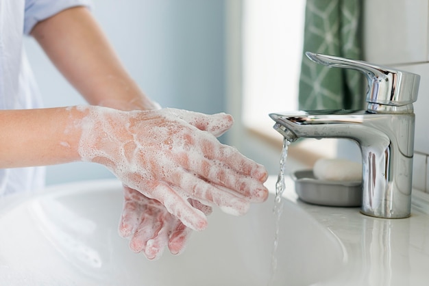 Side view of person washing hands in the sink