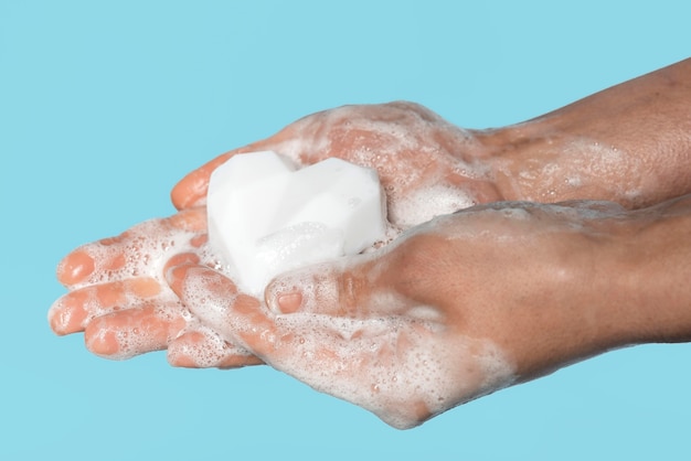Free photo side view person washing hands with a white soap