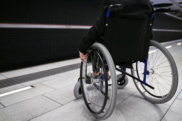 Side view person in wheelchair at subway station