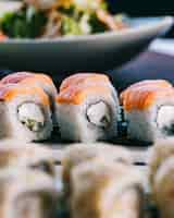 Free photo side view philadelphia roll cream cheese nori cucumber with salmon