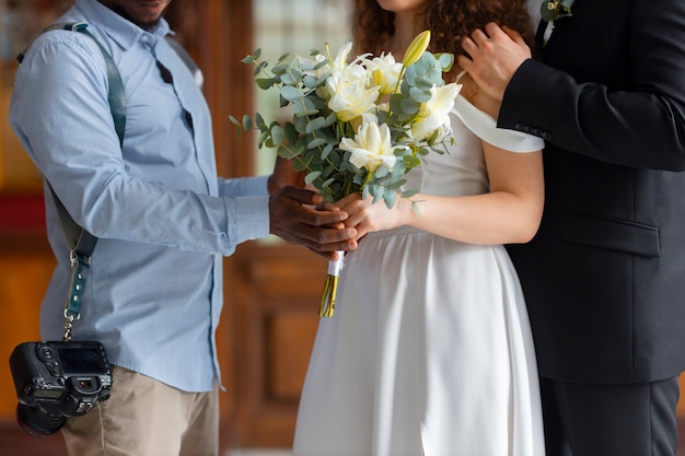 Free photo side view photographer holding flowers