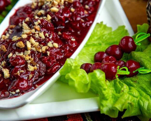 Side view of pickled fruits with walnuts on the table