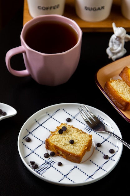 Side view a piece of cake with a cup of tea