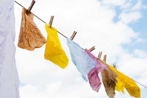 Free photo side view pigmented cloths held by pegs composition