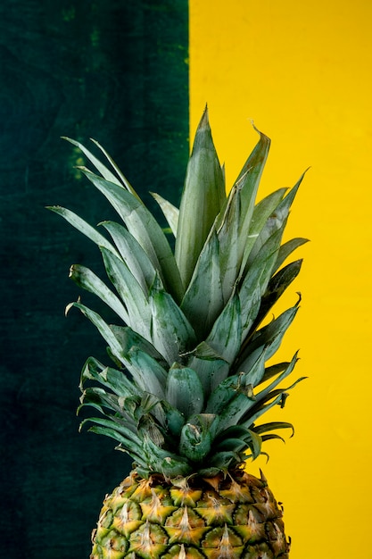 Side view of pineapple on green and yellow surface