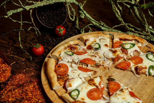 side view pizza on a stand with tomatoes and black pepper