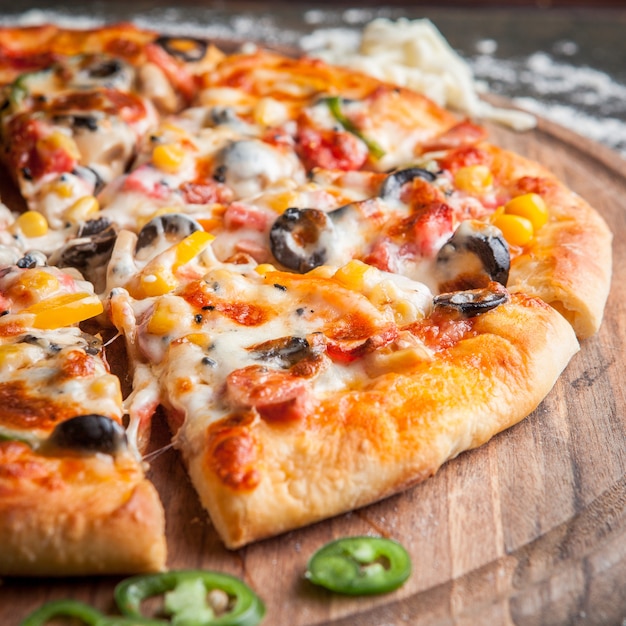 Side view pizza with chopped pepper in board cookware