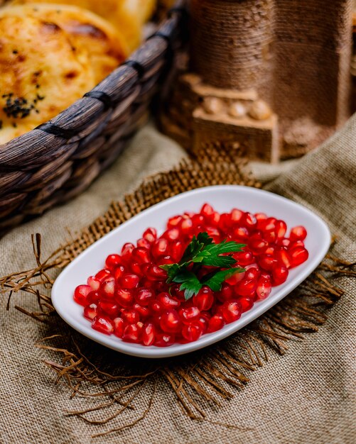 Side view pomegranate and bread on the table