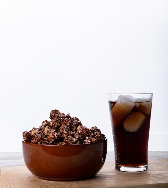 Side view of popcorn in bowl and lemonade on white wooden table vertical