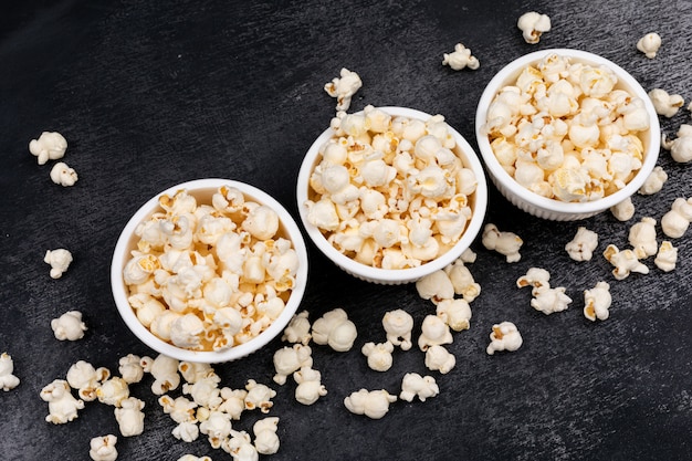 Side view of popcorn in bowls on black  horizontal