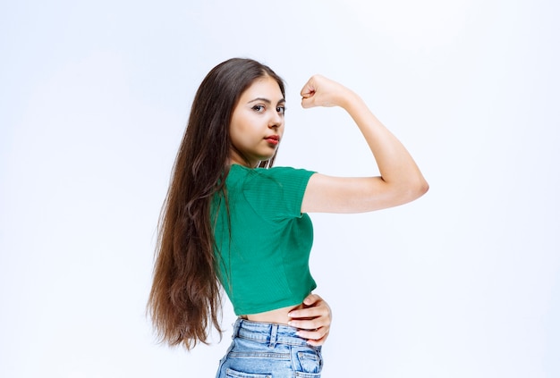 Side view portrait of attractive girl showing muscles .