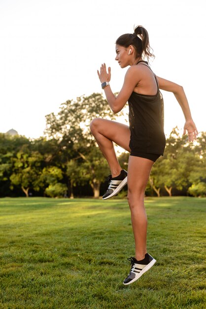 Side view portrait of a fitness woman in earphones