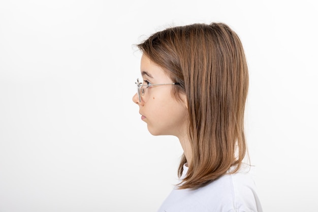 Ritratto laterale di una ragazza con gli occhiali isolati su sfondo bianco