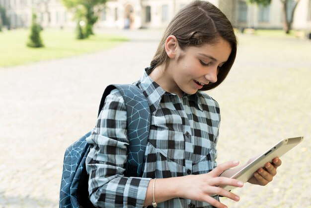 Side view portrait of highschool girl using tablet