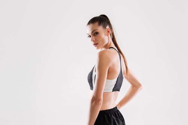 Side view portrait of a pretty fitness woman in sportswear