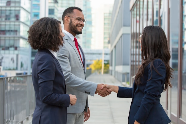 Side view of positive business people handshake