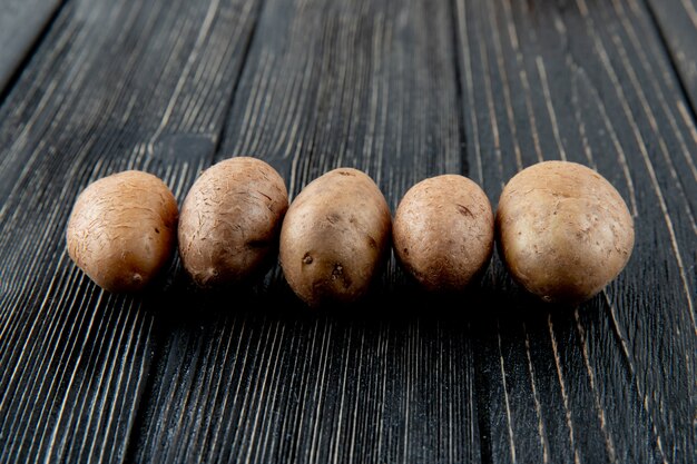 Free photo side view of potatoes on wooden background with copy space 4