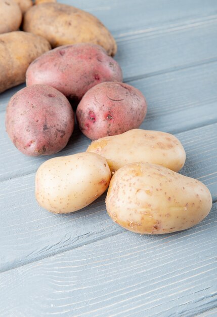 Side view of potatoes on wooden background with copy space