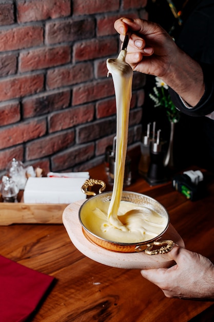 Side view of pouring cake mixture into a baking tin