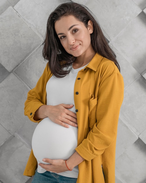 Side view of pregnant woman holding her belly