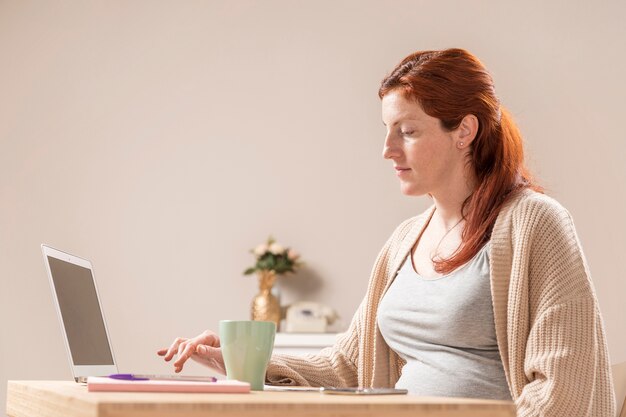 Side view pregnant woman at home