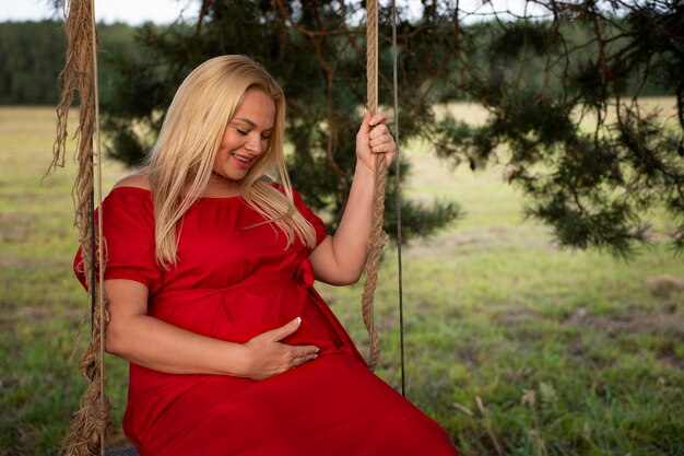 Боковой вид беременная женщина проводит время на открытом воздухе